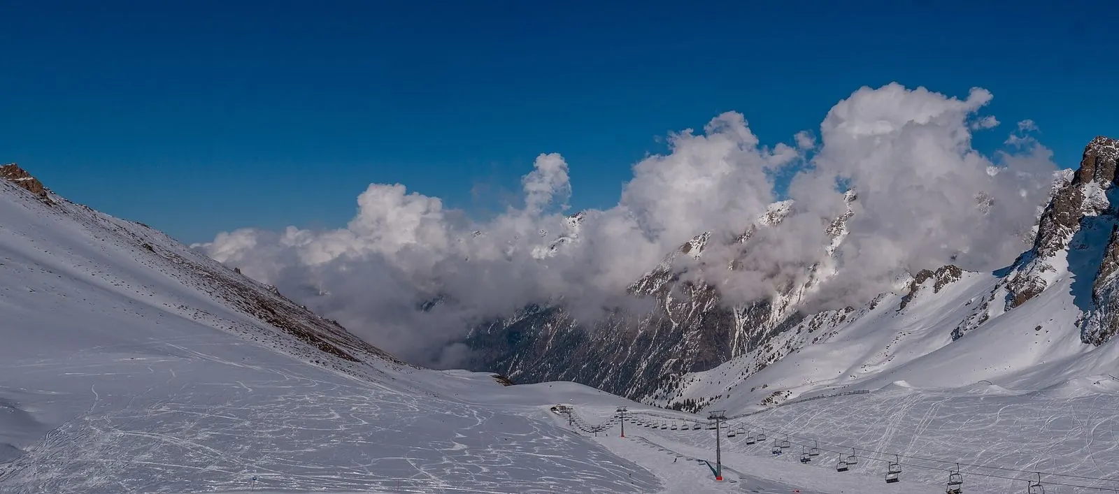 Snow-covered slopes and cloud at the Shymbulak ski resort